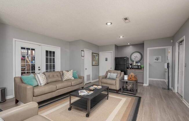 A living room with a couch, coffee table, and a rug.