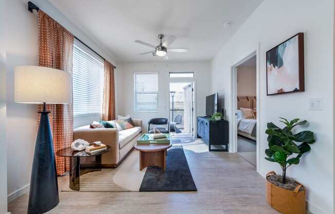 a living room with a couch and a table and a ceiling fan