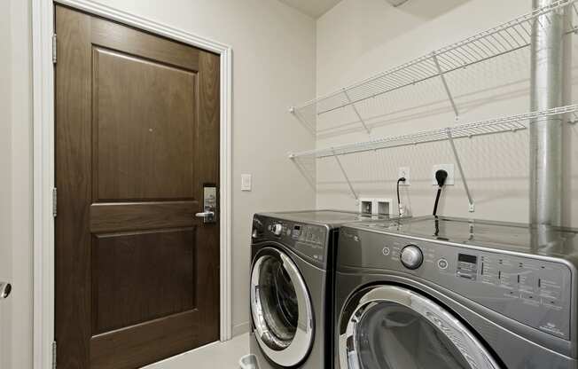 a laundry room with a washer and dryer and a closet with a door