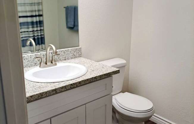A white toilet sits next to a sink in a bathroom.