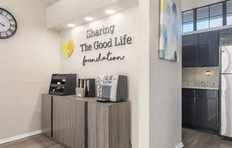 A wall with a clock and a sign that says "Sharing The Good Life Foundation".