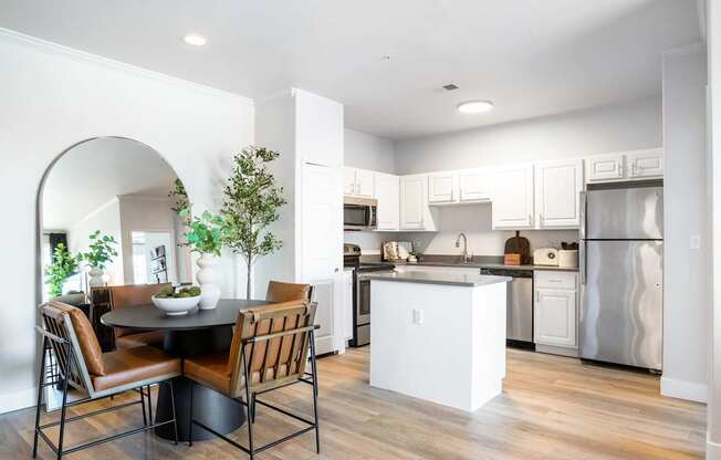 A modern kitchen with a dining table and chairs.