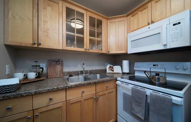 Beautiful kitchen cabinets and granite countertops at the Atrium Apartments in San Diego, California.