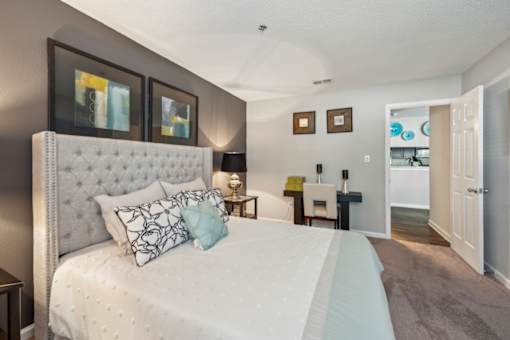 A bedroom with a large bed and a white headboard.