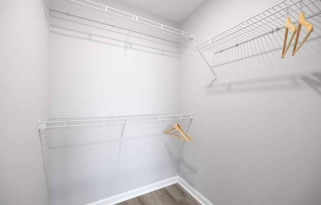 A white closet with a hanger on the left side at Harbor Pointe Apartments, Bayonne, New Jersey