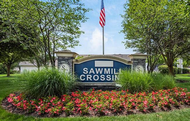A sign that says Sawmill Crossing is in front of a building.