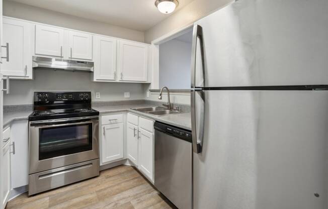 a kitchen with stainless steel appliances and white cabinets