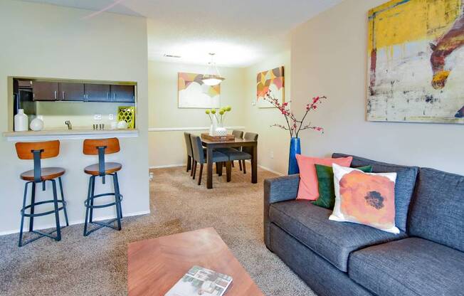A living room with a grey couch and a wooden coffee table.