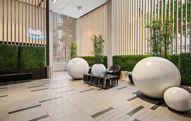 A modern lobby with white spherical objects and a green wall.