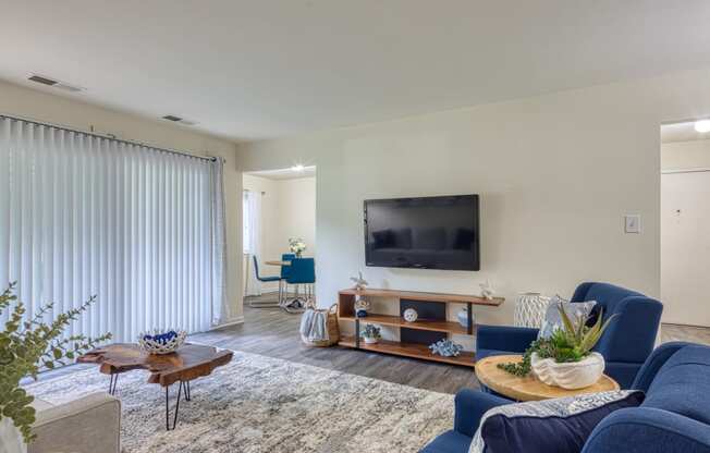 a living room with blue furniture and a tv on the wall