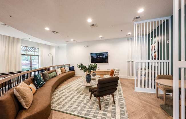 A living room with a brown couch and a rug.