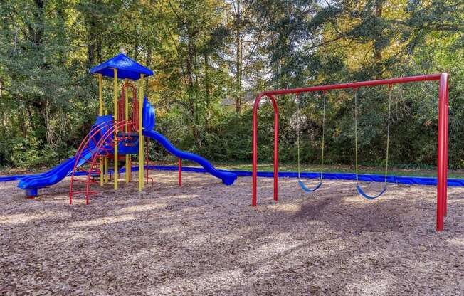 a playground with a blue and red swing set