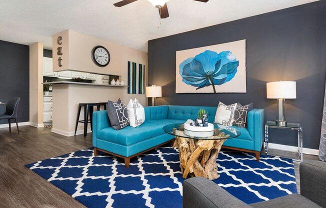 a living room with blue furniture and a blue rug