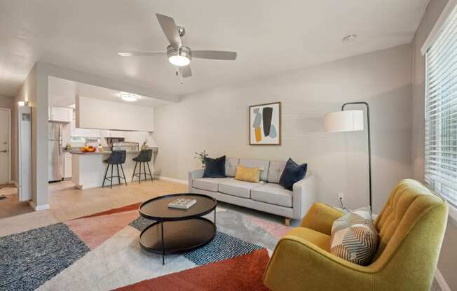 a living room with a couch and a chair and a ceiling fan