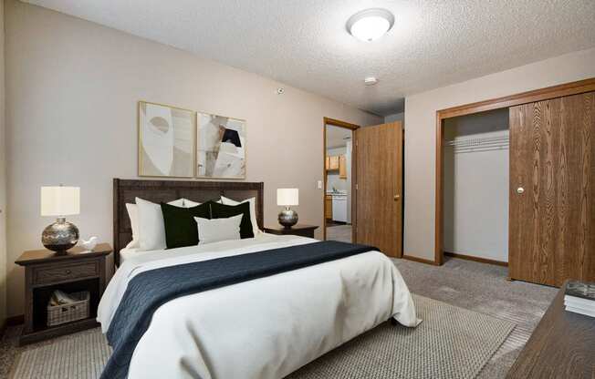 Omaha, NE Deerfield Apartments. A bedroom with a bed and a door to a bathroom
