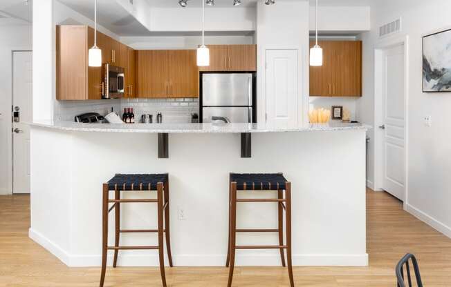 a kitchen with two bar stools in front of a counter top
