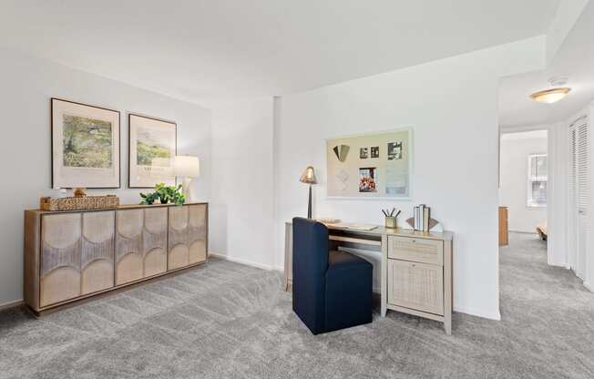 a living room with a blue chair and a desk