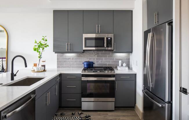 A modern kitchen with a stove, oven, and refrigerator.