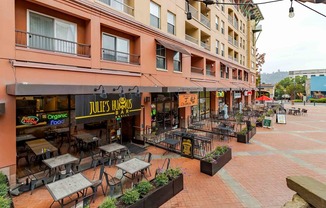 A restaurant named Jules Trumbo is located in a courtyard with tables and chairs.