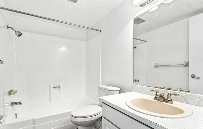 a white bathroom with a sink and a toilet