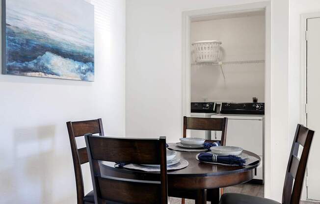 dining area in the model unit at Skyler Ridge Apartments, with a table, chairs, and artwork on the wall.