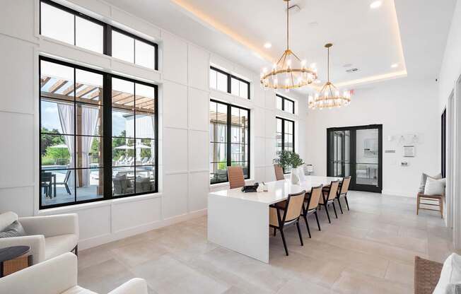 A modern living room with a long white table and chairs.