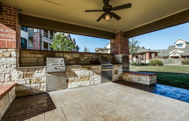 a covered patio with an outdoor kitchen and a pool at Platinum Castle Hills, Lewisville, Texas