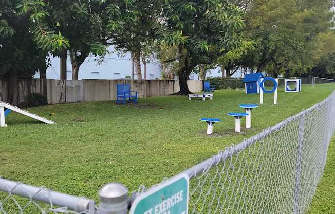 a park with benches and tables in the grass