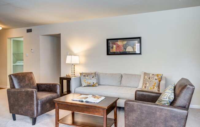 a living room with a couch and chairs and a coffee table