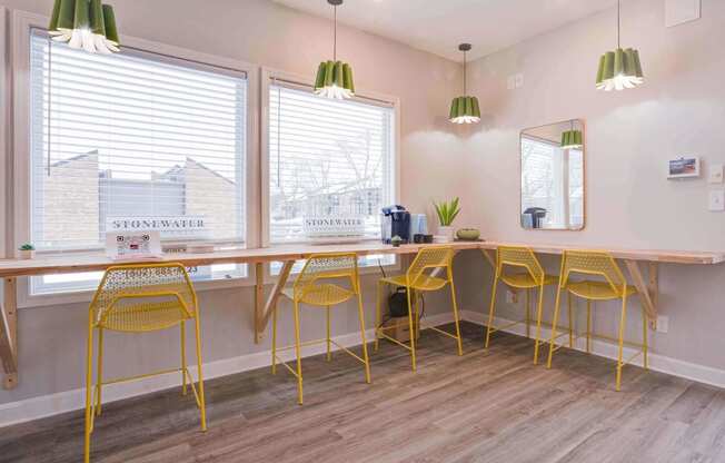 a long table with yellow chairs and a mirror on the wall at Stonewater Apartments, Louisville Kentucky