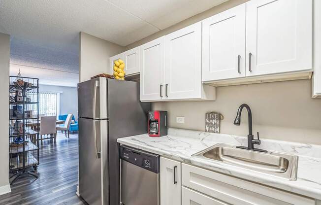 A kitchen with a refrigerator, dishwasher, and sink.