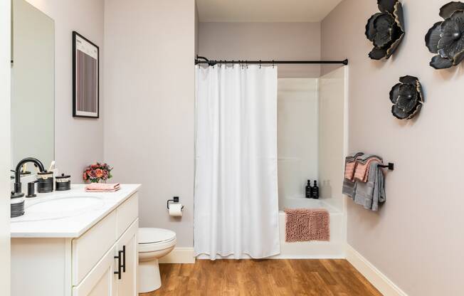 a bathroom with a white sink and toilet and a white shower curtain