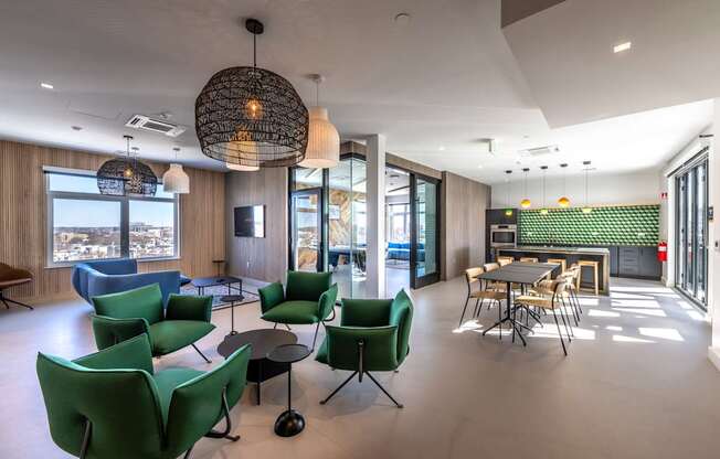 A modern room with green chairs and a large window overlooking a cityscape.