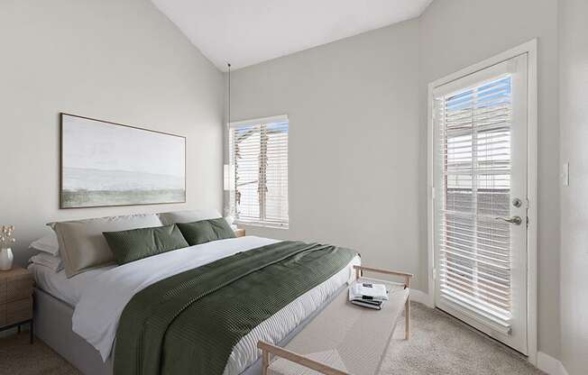 Model Bedroom with Carpet and Patio Accessibility at Crystal Creek Apartments in Phoenix, AZ.