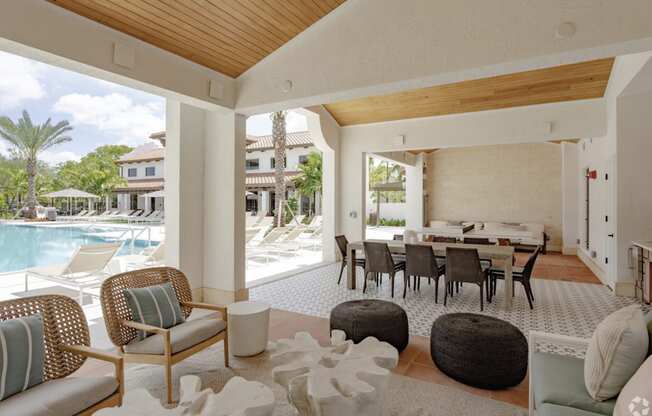 a living room and dining area with a pool in the background