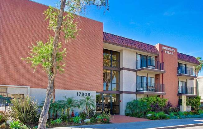 a large brick building with a tree in front of it  at Sherway Villa, Reseda