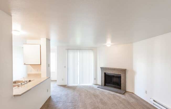 a living room with a fireplace and a kitchen