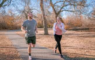 A man and a woman running down a road at Legends of River Oaks