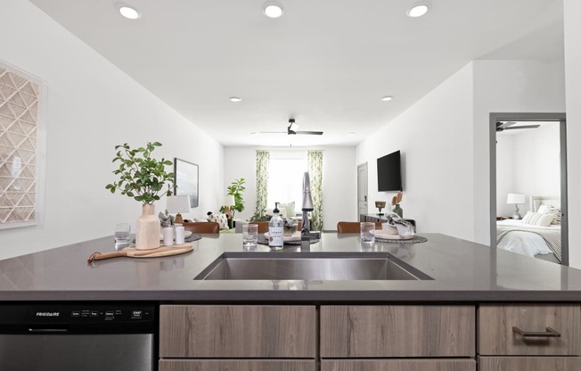 a modern kitchen with a large sink and a living room in the background at Palm Grove in Ellenton, FL 34222