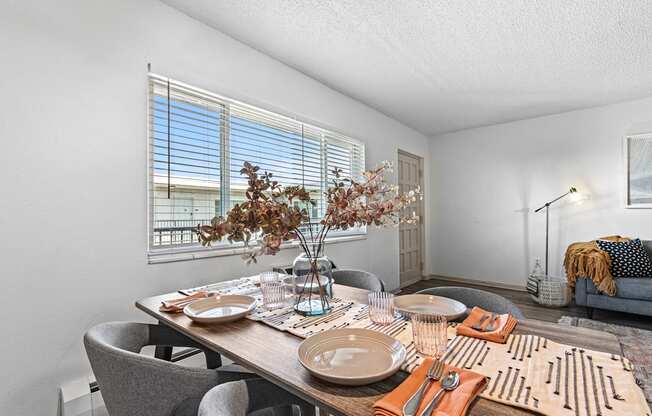 a dining room with a table and chairs and a window