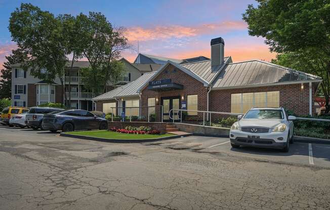 A parking lot with a white car parked in front of a building with a sign that says "STATE".