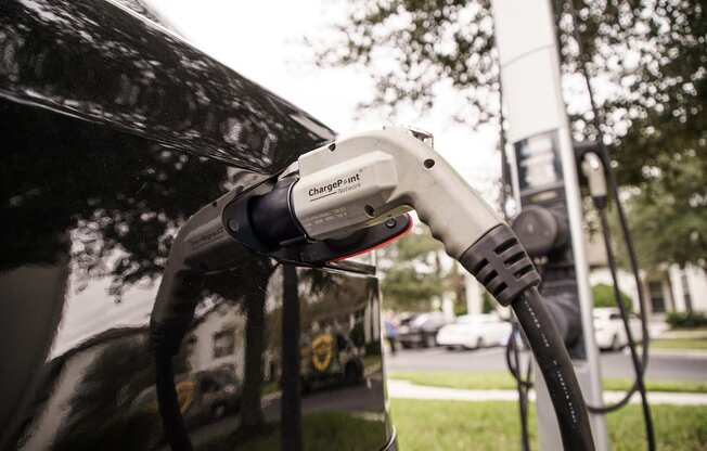Electric car charger plugged into car at Lake Nona Water Mark in Orlando, FL 32827
