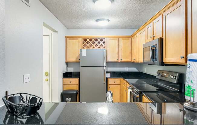A kitchen with wooden cabinets and a black countertop.