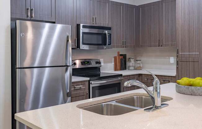 The Hendrix Apartments a kitchen with stainless steel appliances and a sink at The Hendrix, Atlanta, Georgia