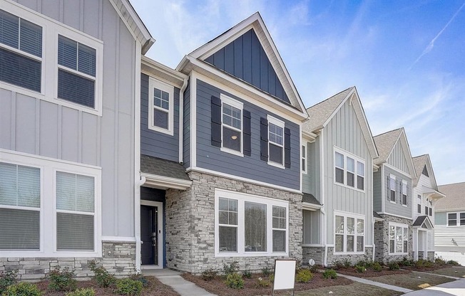 A row of houses with a mix of grey and white siding.