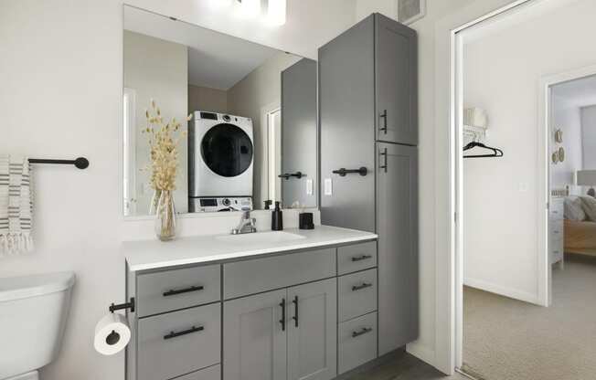 a bathroom with gray cabinets and a white countertop