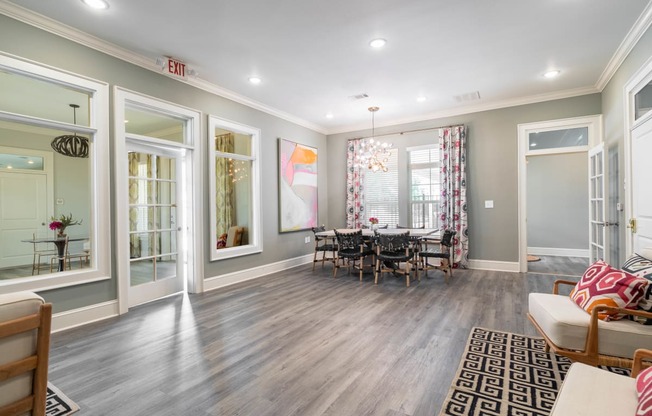 a living room with a dining room table and windows