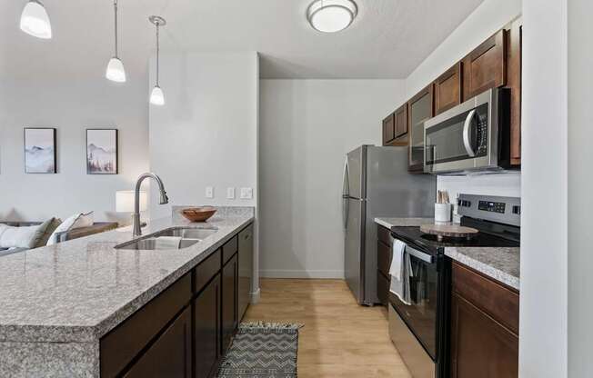 A kitchen with a granite countertop and stainless steel appliances.