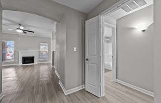 an empty living room with a ceiling fan and a fireplace
