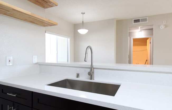 an empty kitchen with a sink and a faucet